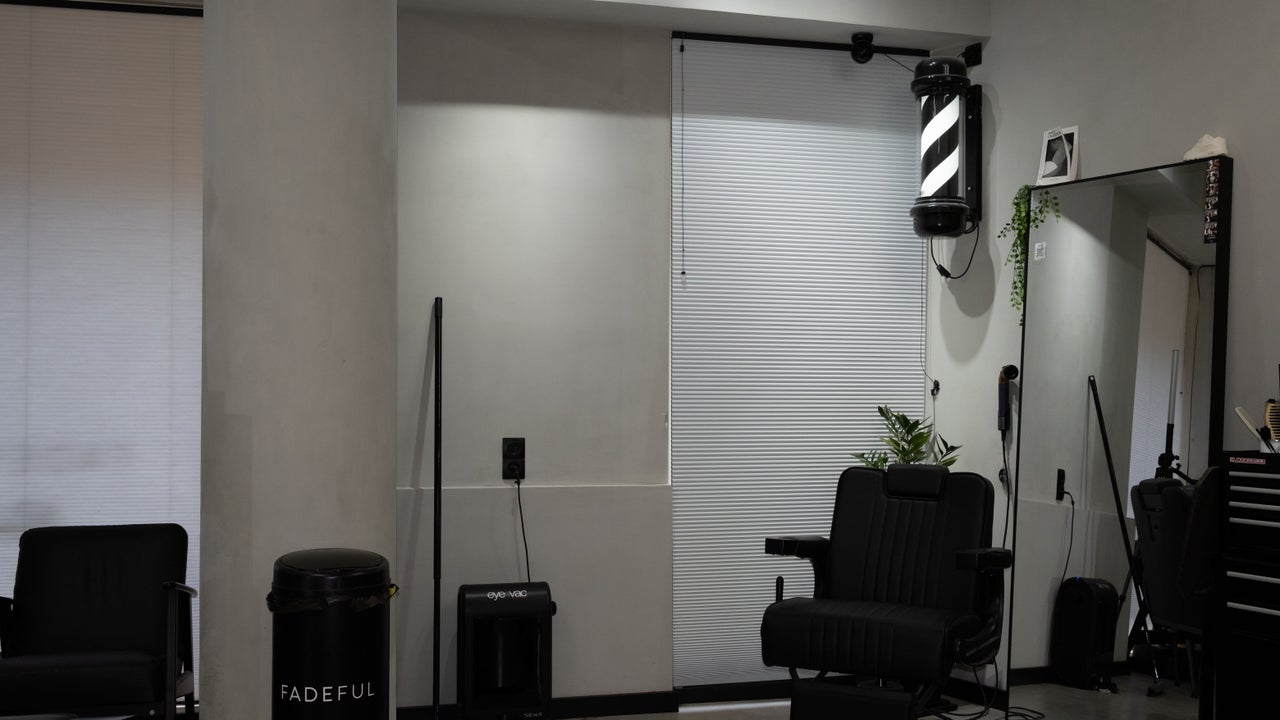Barberstoelen, een spiegel en de barberpaal bij het raam